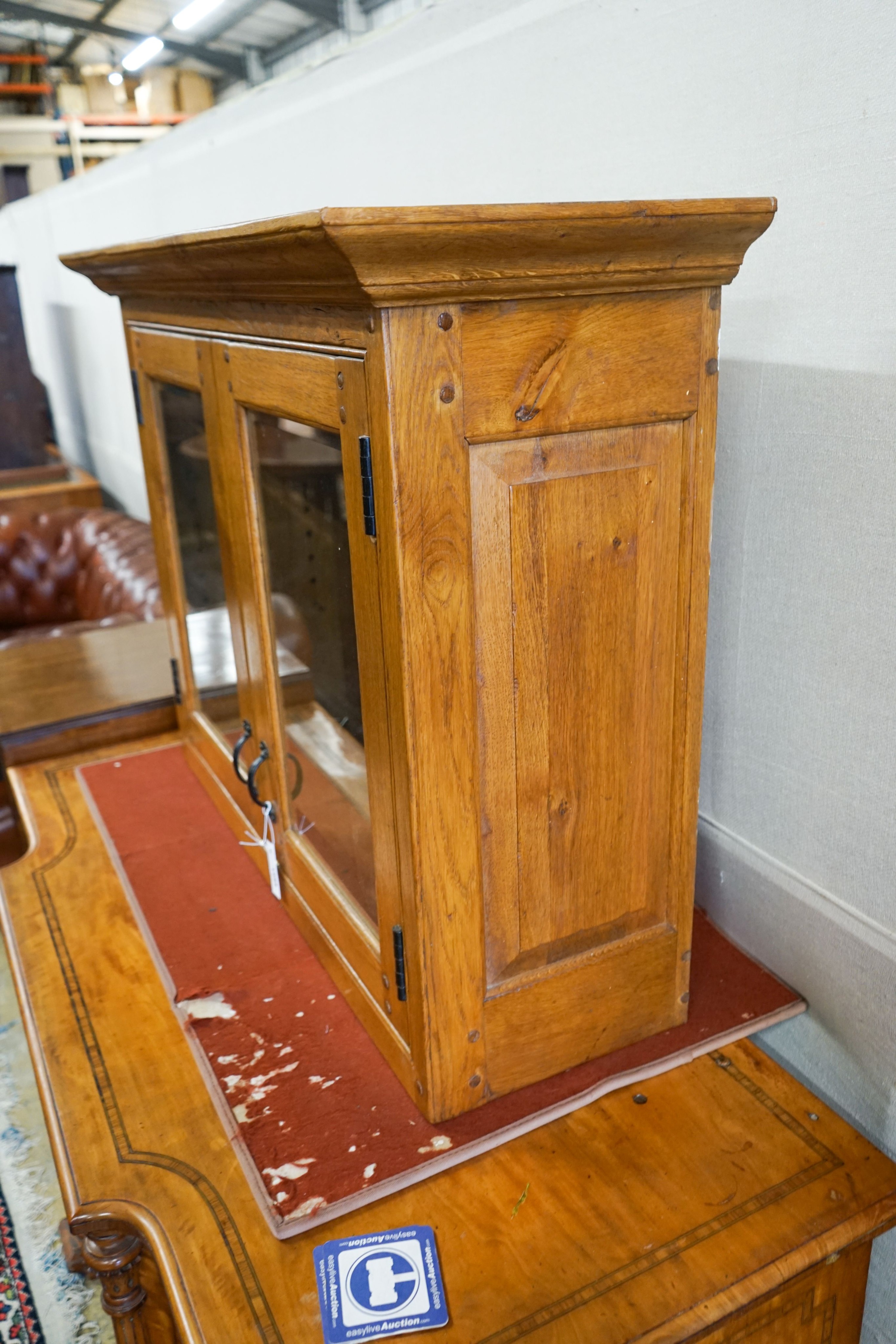 A glazed oak two door wall cabinet, width 107cm, depth 37cm, height 80cm